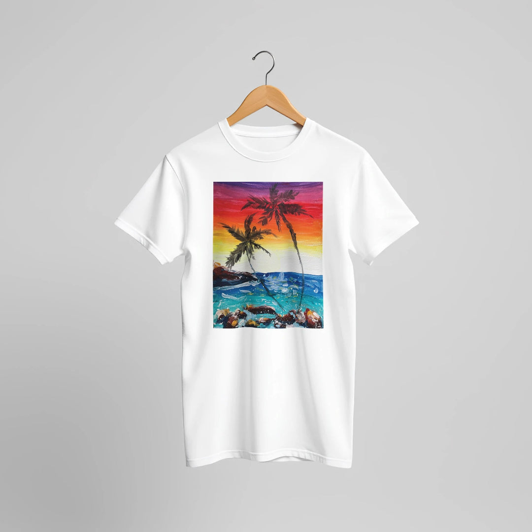 White t-shirt with a tropical beach design featuring palm trees and a sunset on a hanger against a grey background.