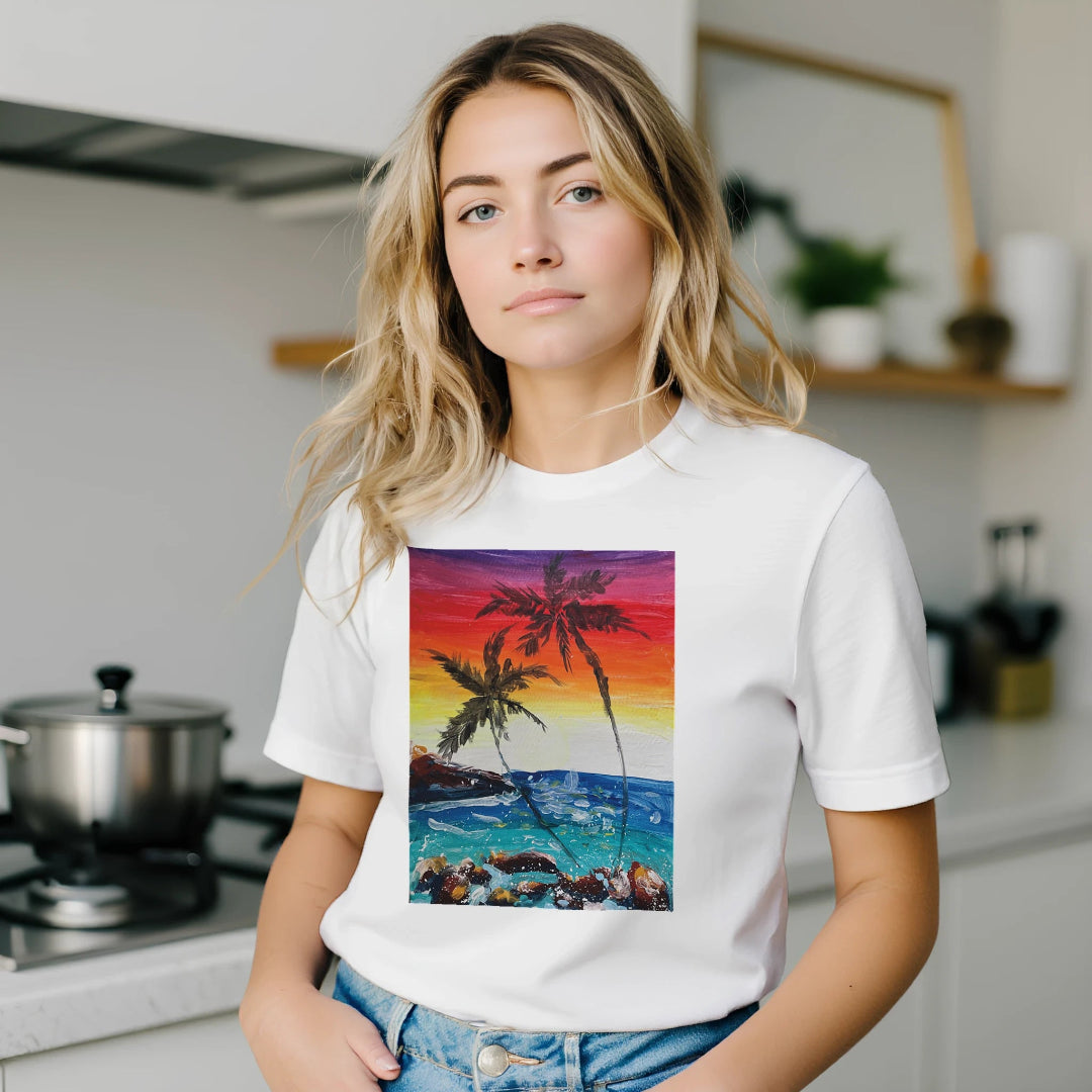 Woman wearing a white t-shirt with a colorful palm tree design in a kitchen.