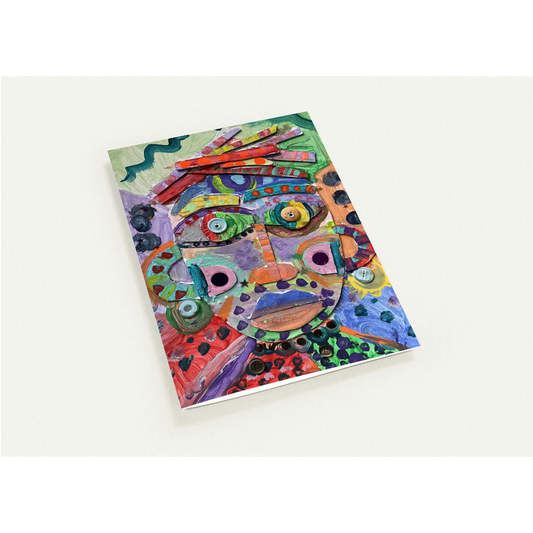 Colorful abstract face design on a notebook cover against a white background
