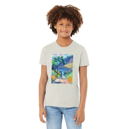 Boy wearing a t-shirt with a colourful landscape design on a white background